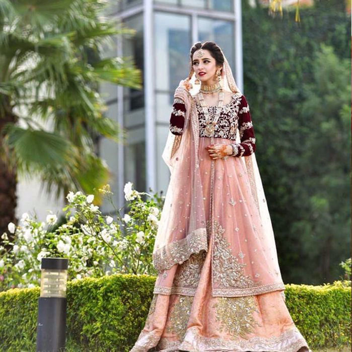 Picture of Absolutely head over heels in love with our bride carrying our effeminate coral Meherma outfit with a blush maroon velvet bodice
